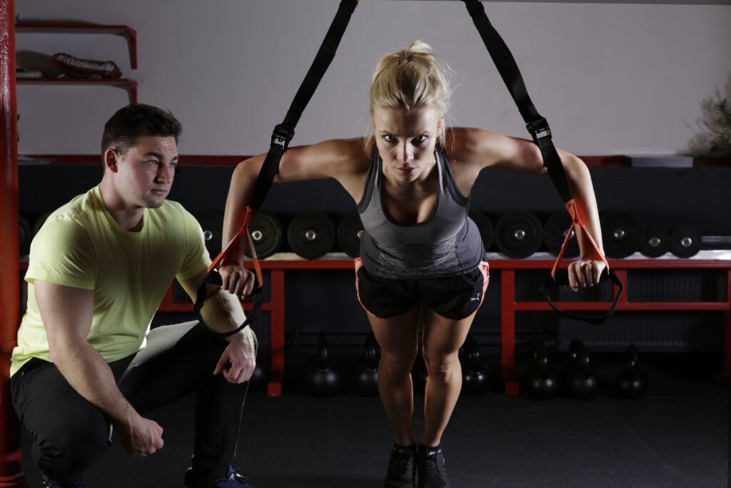 Man guiding woman in sport specific exercises for strength and conditioning